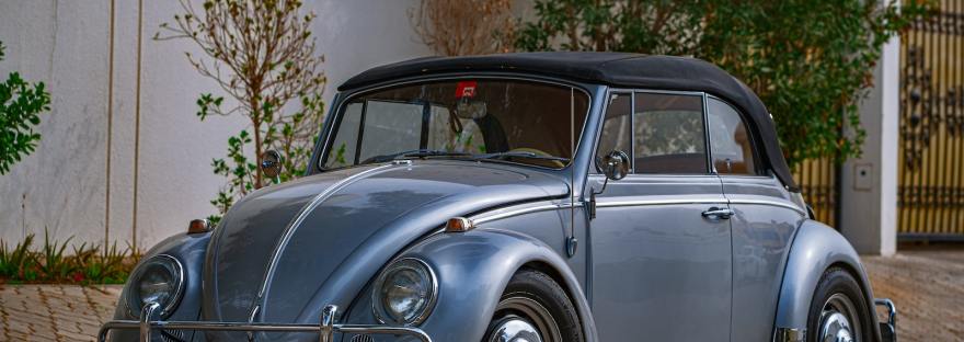 blue classic car parked near white building