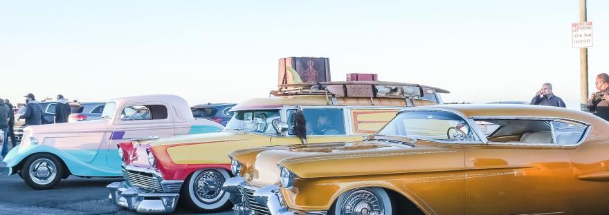 yellow and white vintage cars on parking lot during daytime
